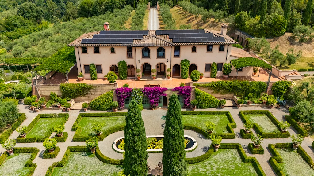 Aerial view of a Tuscan estate with olive grove and panoramic pool in the hills near Pisa